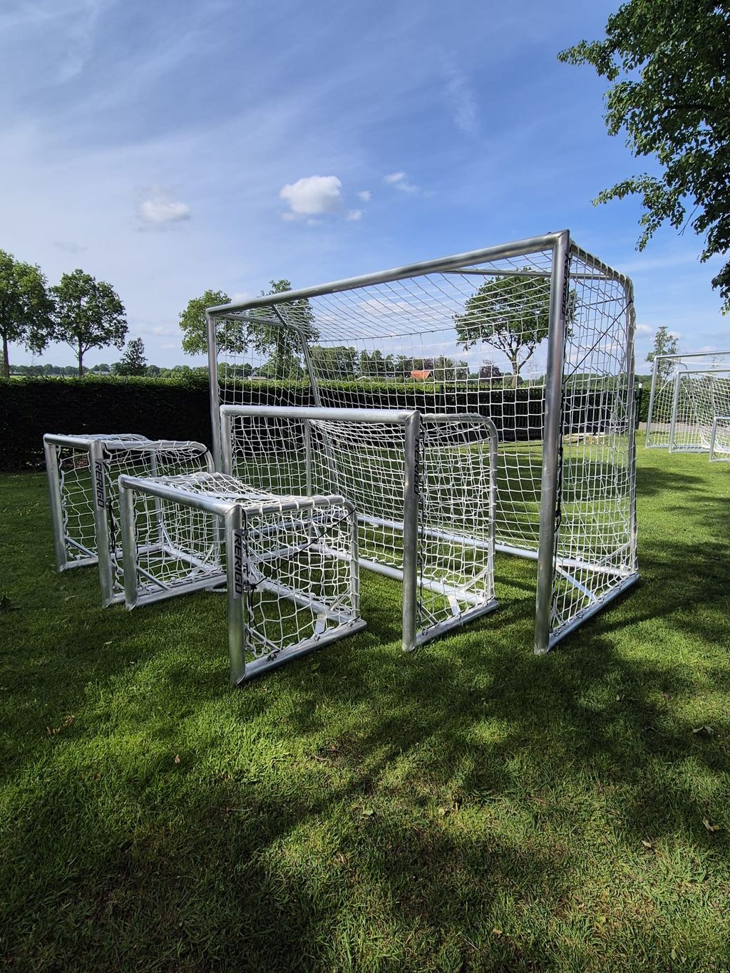 Meerdere aluminium doelen in verschillende maten naast elkaar op een grasveld