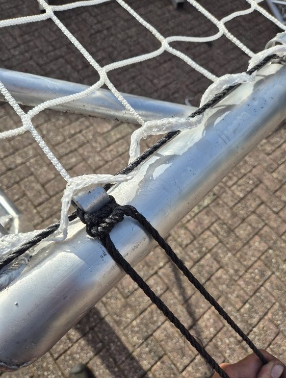 De knoop zit vast aan de onderbalk van het doel